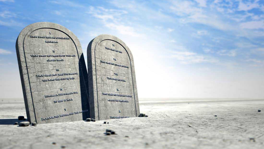 The ten commandments on brown desert sand.