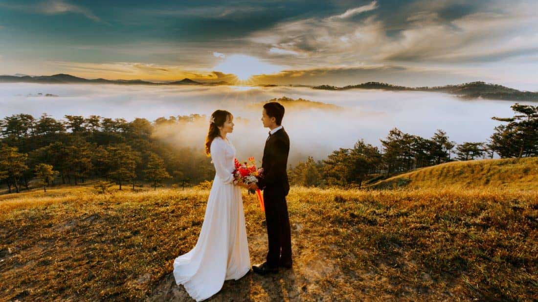 An asian couple getting married in front of a beautiful landscape.